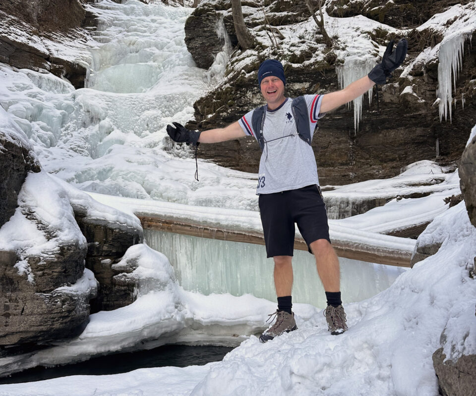 Учасник LIFEPEAK біля замерзлого водоспаду в зимових горах